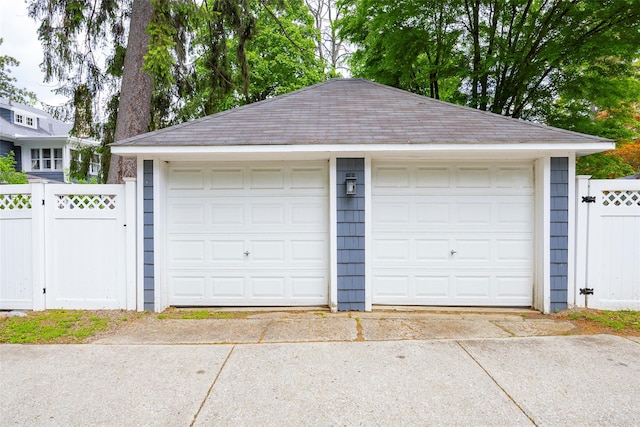 detached garage with fence and a gate