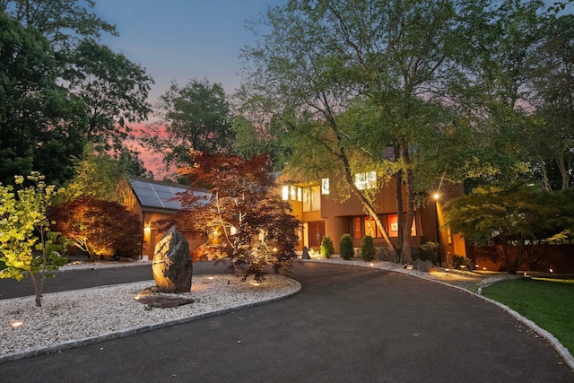 5 Ponds Ln, Purchase, NY 10577 - view of front facade featuring roof mounted solar panels and curved driveway