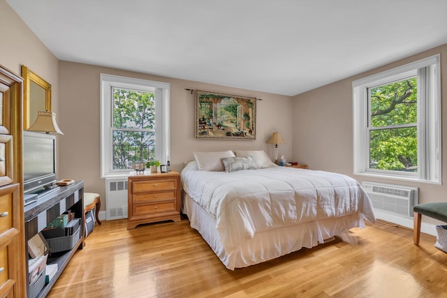 209-25 18th Ave Unit 3J, Bayside, NY 11360 - bedroom featuring radiator heating unit, light wood-style floors, and a wall unit AC