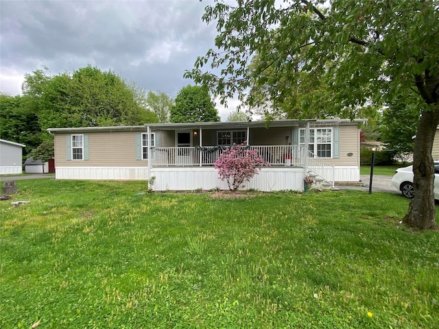 manufactured / mobile home featuring covered porch and a front lawn