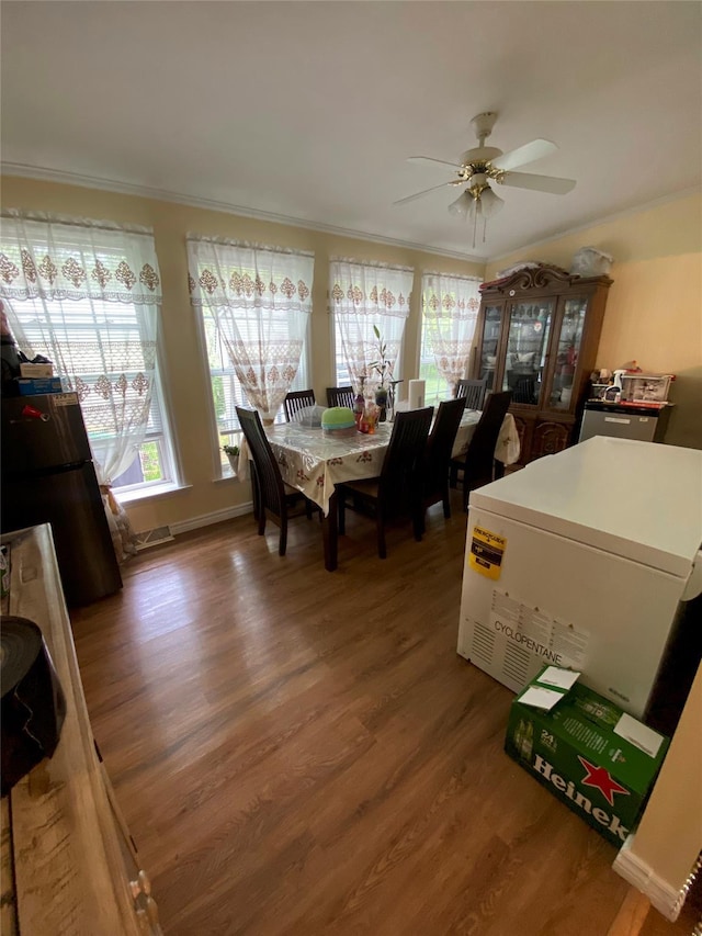 dining room featuring wood finished floors, a ceiling fan, and crown molding