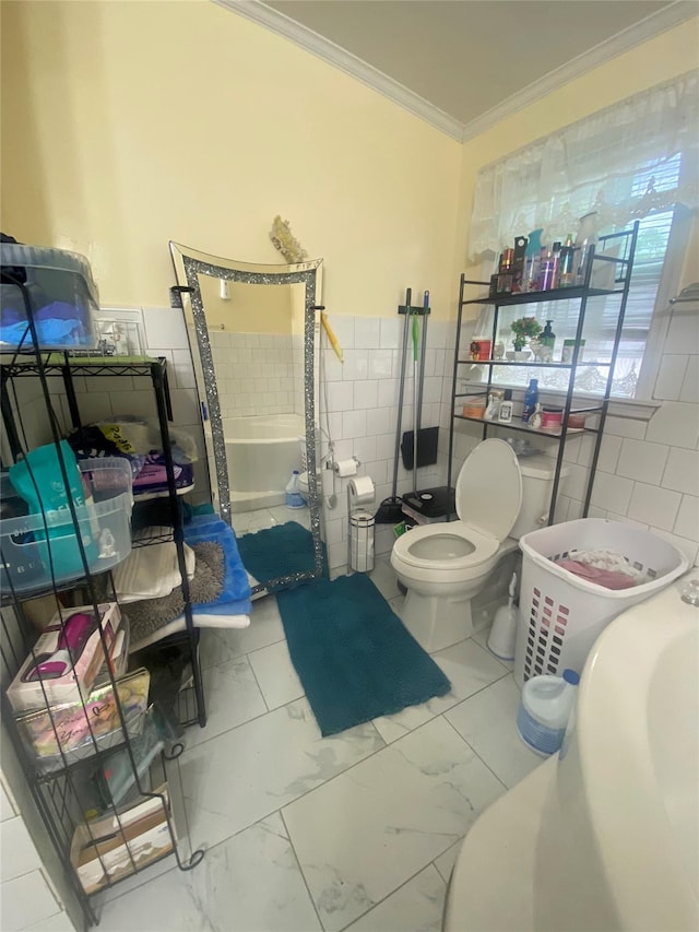bathroom featuring crown molding, tile walls, toilet, marble look tile flooring, and wainscoting