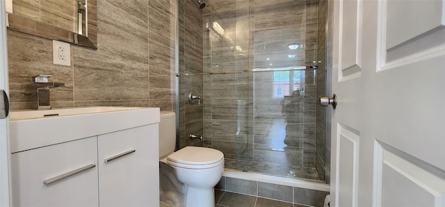 bathroom featuring toilet, a stall shower, vanity, and tile patterned flooring