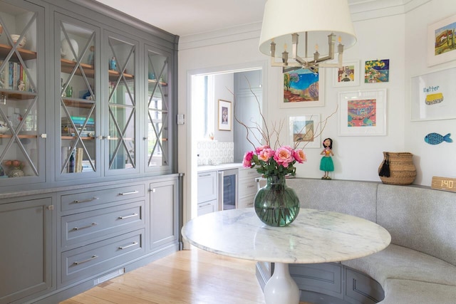 dining space featuring wine cooler and crown molding