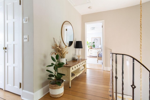 hall with wood-type flooring and baseboards