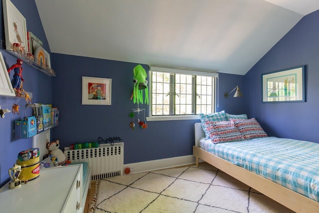 bedroom featuring lofted ceiling, radiator, light carpet, and baseboards