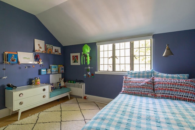bedroom with radiator heating unit, vaulted ceiling, and baseboards