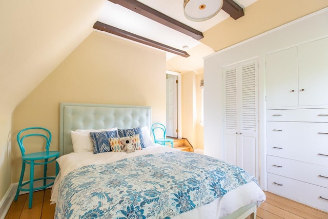 bedroom featuring light wood finished floors and lofted ceiling