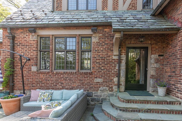 property entrance featuring an outdoor hangout area, brick siding, and a high end roof