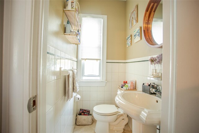 445 W Walnut St, Long Beach, NY 11561 - bathroom featuring tile walls, tile patterned floors, toilet, wainscoting, and a sink
