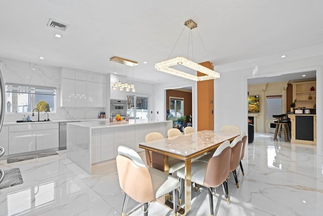 dining room with light marble finish flooring, recessed lighting, and a chandelier