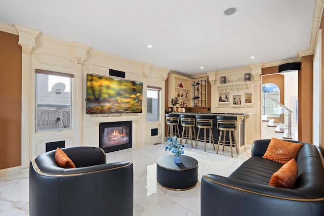 living area featuring marble tiled flooring, a glass covered fireplace, healthy amount of natural light, recessed lighting, and stairs