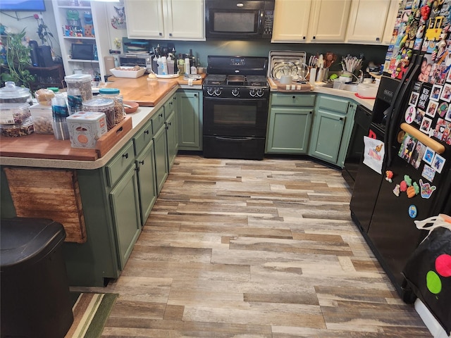 9-16 Bch 98th St, Rockaway Park, NY 11694 - kitchen with green cabinetry, black appliances, light wood-type flooring, a sink, and light countertops