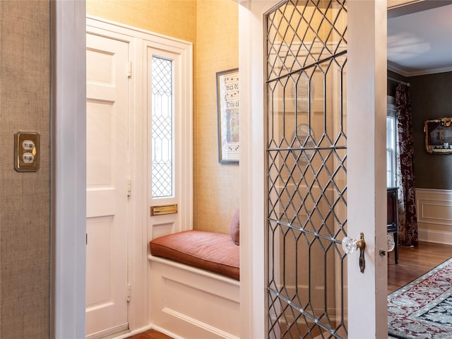 entryway featuring ornamental molding and wood finished floors