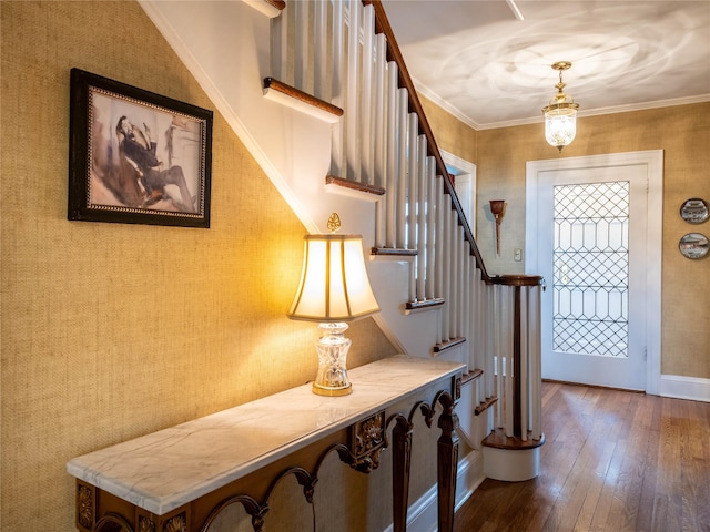 foyer featuring wood-type flooring, stairs, baseboards, and wallpapered walls