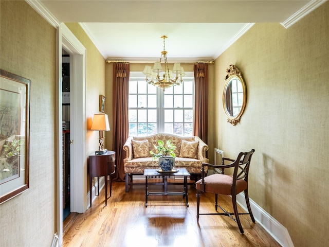sitting room featuring wood finished floors, a chandelier, crown molding, wallpapered walls, and baseboards