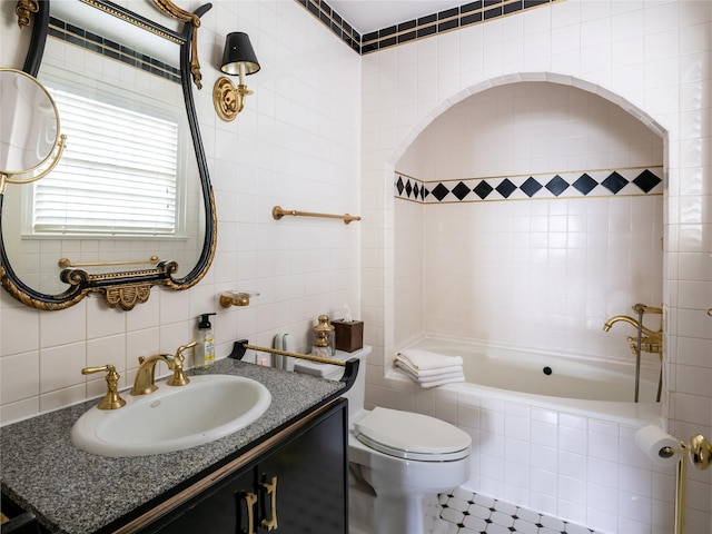 full bathroom featuring tile walls, vanity, toilet, tiled shower / bath combo, and decorative backsplash