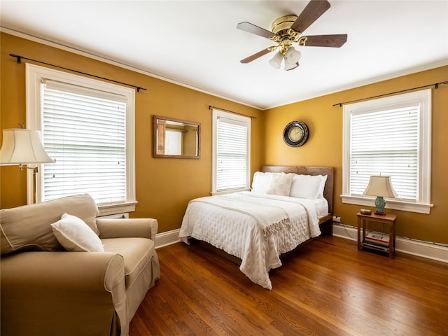 bedroom with baseboards, dark wood finished floors, crown molding, multiple windows, and ceiling fan
