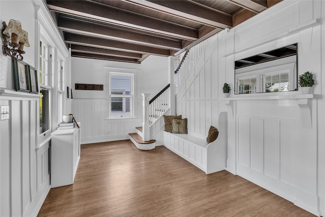 46 Mechanic St, Huntington, NY 11743 - foyer entrance with stairway, a decorative wall, wood finished floors, a wainscoted wall, and wooden ceiling with exposed beams