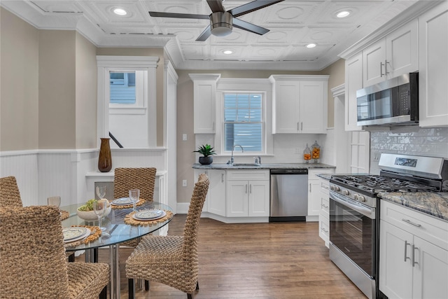 46 Mechanic St, Huntington, NY 11743 - kitchen featuring stainless steel appliances, a sink, ceiling fan, white cabinetry, and ornamental molding