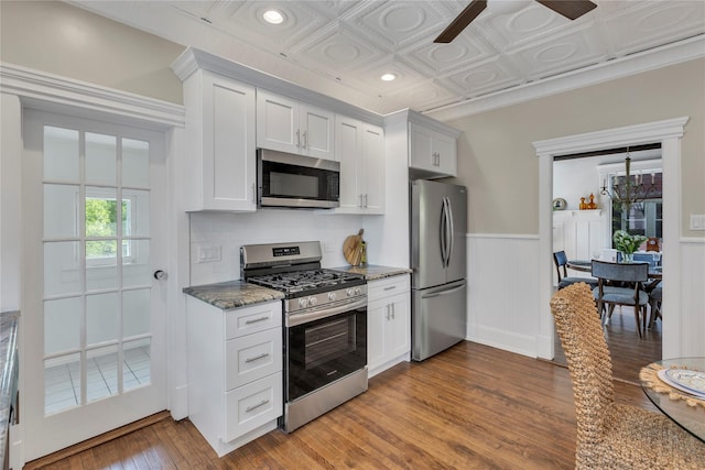 46 Mechanic St, Huntington, NY 11743 - kitchen featuring stainless steel appliances, wood finished floors, a ceiling fan, white cabinetry, and a wainscoted wall
