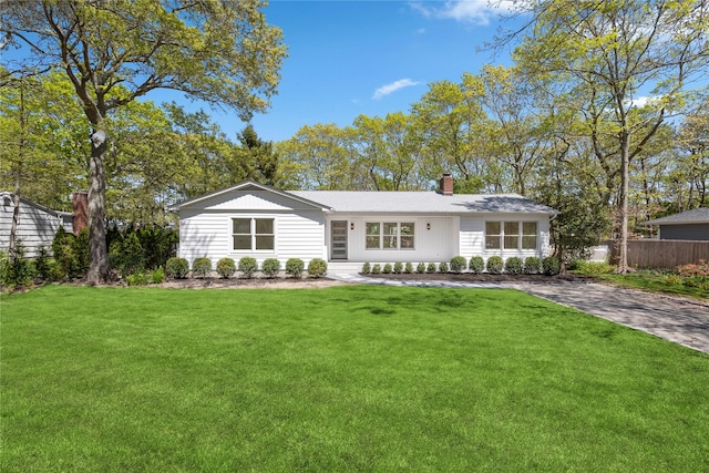 4 Pine Tree Ct, East Quogue, NY 11942 - rear view of house featuring a chimney
