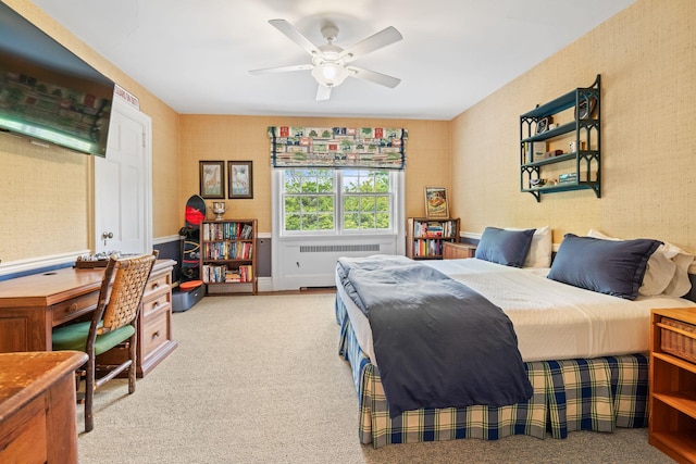 carpeted bedroom with radiator heating unit, ceiling fan, and an office area