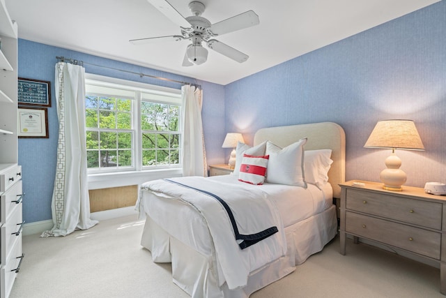 bedroom with light carpet, ceiling fan, and baseboards