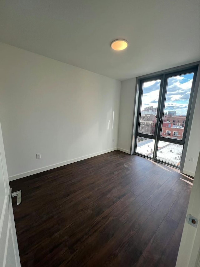 144-27 Sanford Ave Unit 6L, Flushing, NY 11355 - spare room featuring dark wood finished floors, expansive windows, and baseboards