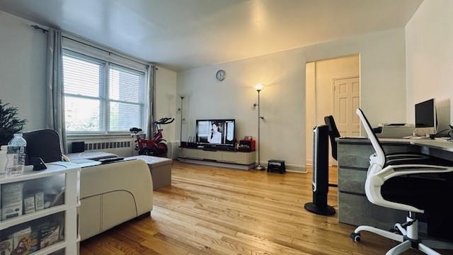 office space with radiator heating unit and light wood-type flooring