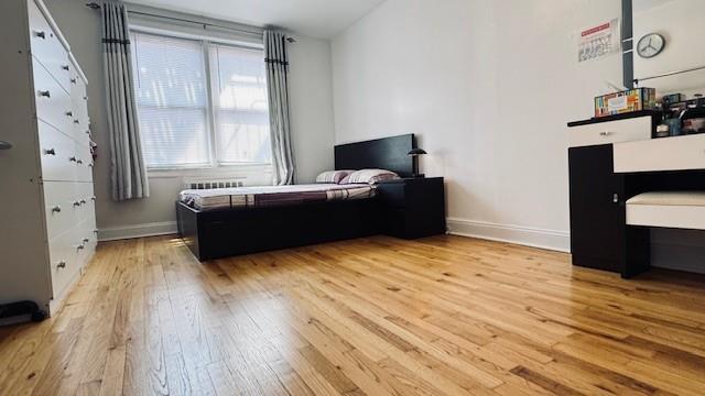bedroom featuring hardwood / wood-style flooring and baseboards