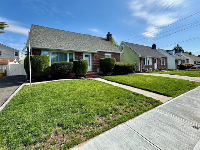 bungalow-style home with a gate, brick siding, and a shingled roof