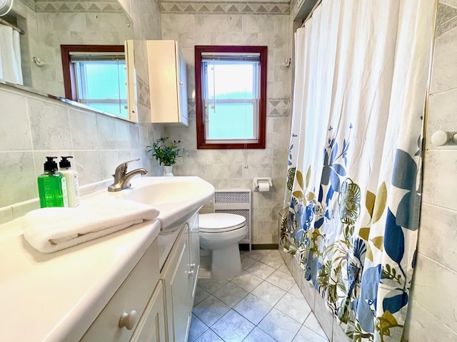 bathroom featuring tile walls, toilet, vanity, a shower with shower curtain, and radiator heating unit