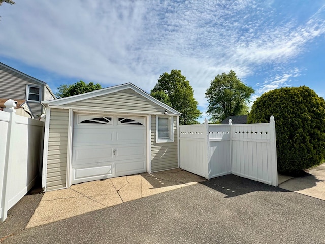 detached garage with fence and driveway
