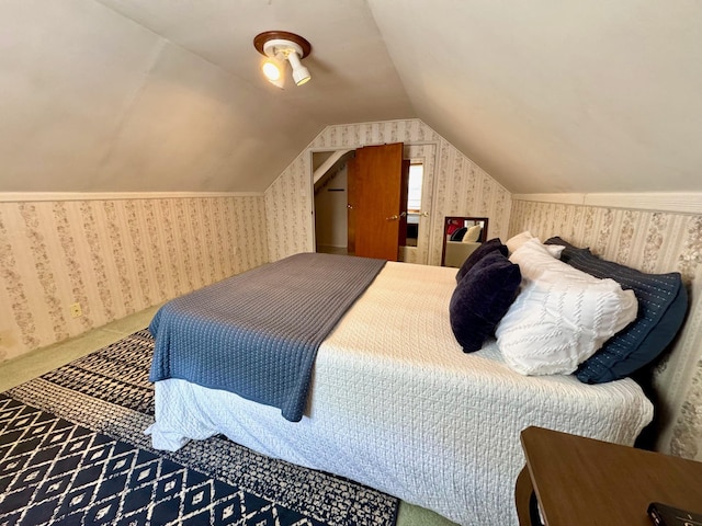 carpeted bedroom featuring wallpapered walls and vaulted ceiling