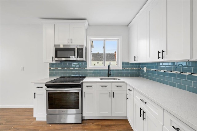 121 Arlington Ave, Wyandanch, NY 11798 - kitchen featuring stainless steel appliances, a sink, light countertops, and wood finished floors