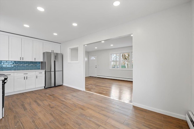121 Arlington Ave, Wyandanch, NY 11798 - kitchen featuring freestanding refrigerator, a baseboard radiator, light countertops, white cabinetry, and recessed lighting