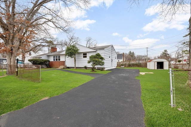 121 Arlington Ave, Wyandanch, NY 11798 - single story home with a chimney, asphalt driveway, an outdoor structure, and a shed