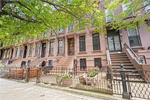 view of property featuring stairway and a fenced front yard