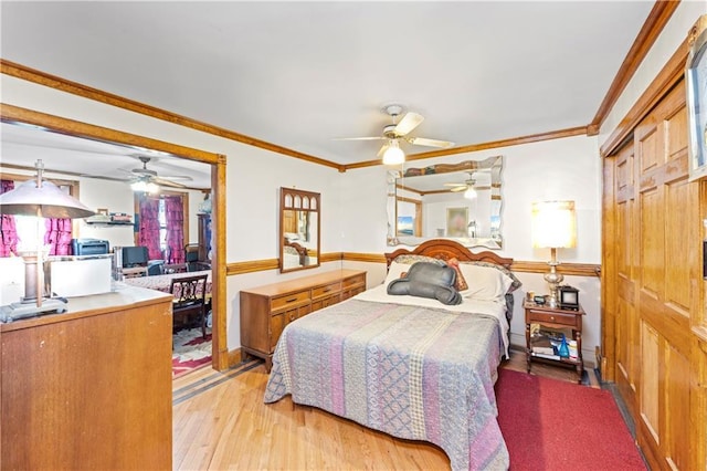 bedroom with wood finished floors, crown molding, and ceiling fan