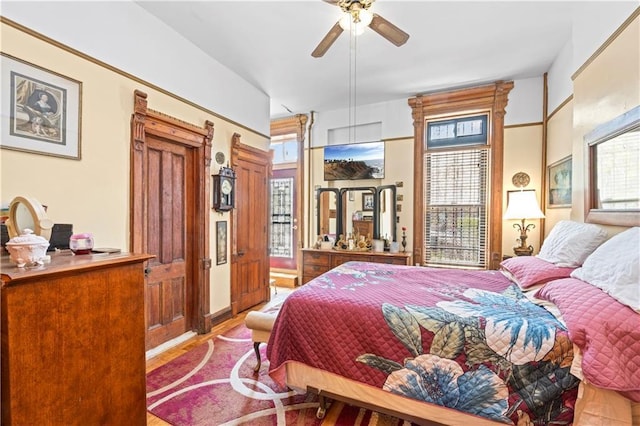 bedroom with multiple windows and wood finished floors