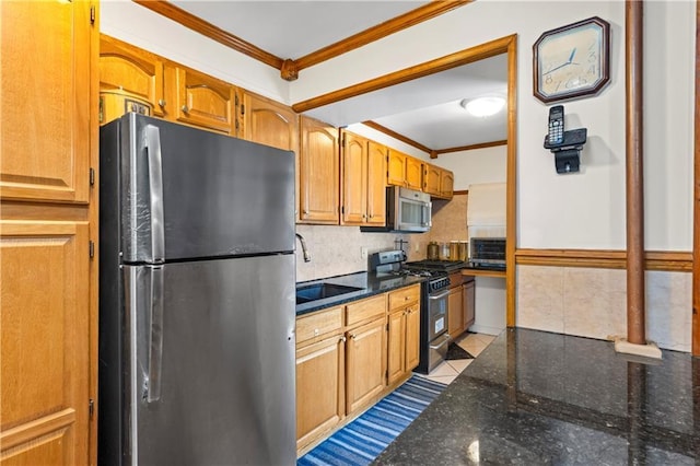 kitchen with stainless steel appliances, ornamental molding, dark stone counters, a sink, and backsplash