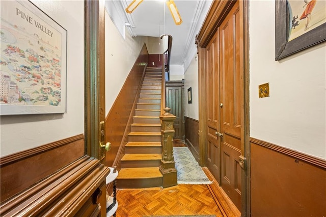 hall featuring a wainscoted wall and stairway