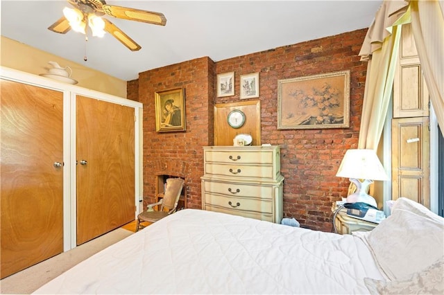 bedroom featuring brick wall, multiple closets, and ceiling fan