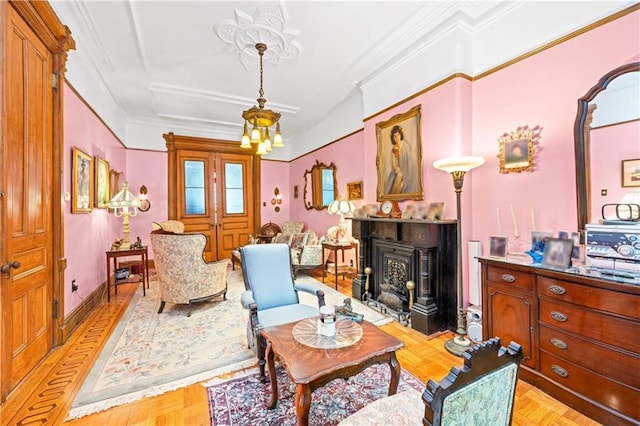 sitting room featuring a fireplace, ornamental molding, and a chandelier