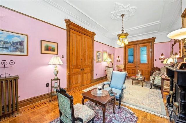 living area featuring a chandelier, ornamental molding, and a tray ceiling