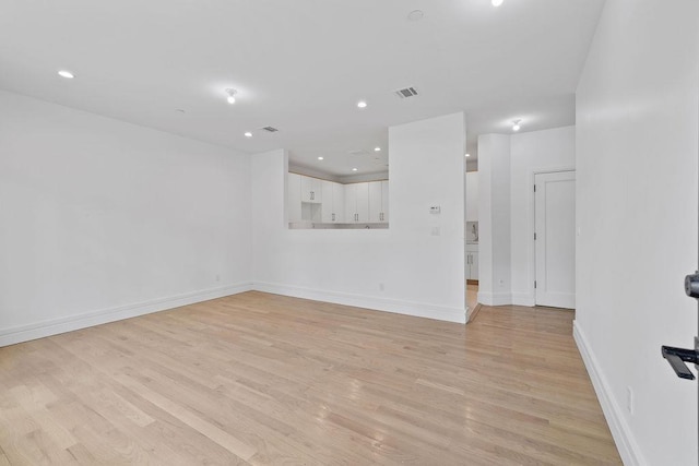 unfurnished living room with light wood-style floors, baseboards, and recessed lighting