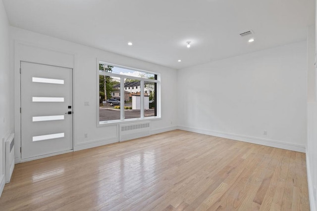 foyer entrance featuring radiator, light wood-style floors, baseboards, and recessed lighting