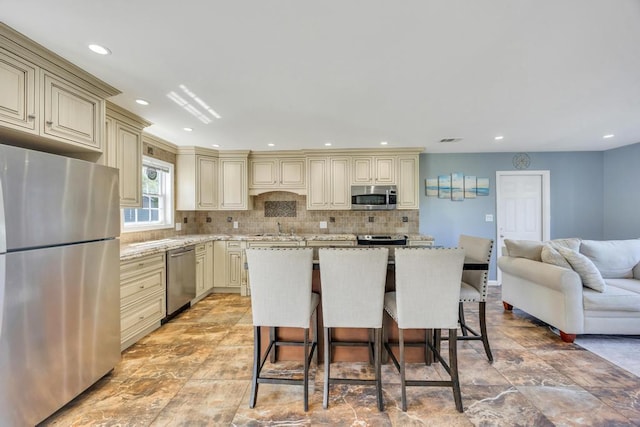 59 Saddle Ln, Levittown, NY 11756 - kitchen featuring cream cabinets, appliances with stainless steel finishes, a sink, decorative backsplash, and recessed lighting