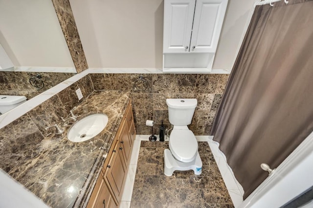 59 Saddle Ln, Levittown, NY 11756 - bathroom with vanity, toilet, tile walls, a wainscoted wall, and tile patterned floors